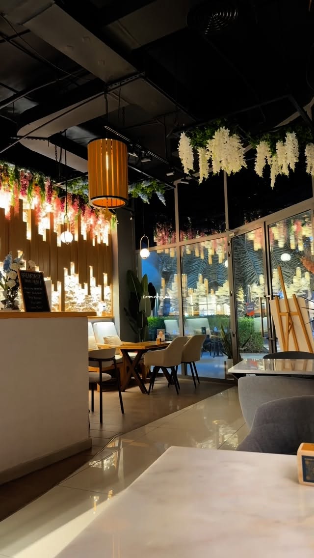 Inside Coffeine at night, warm lights and wooden tables